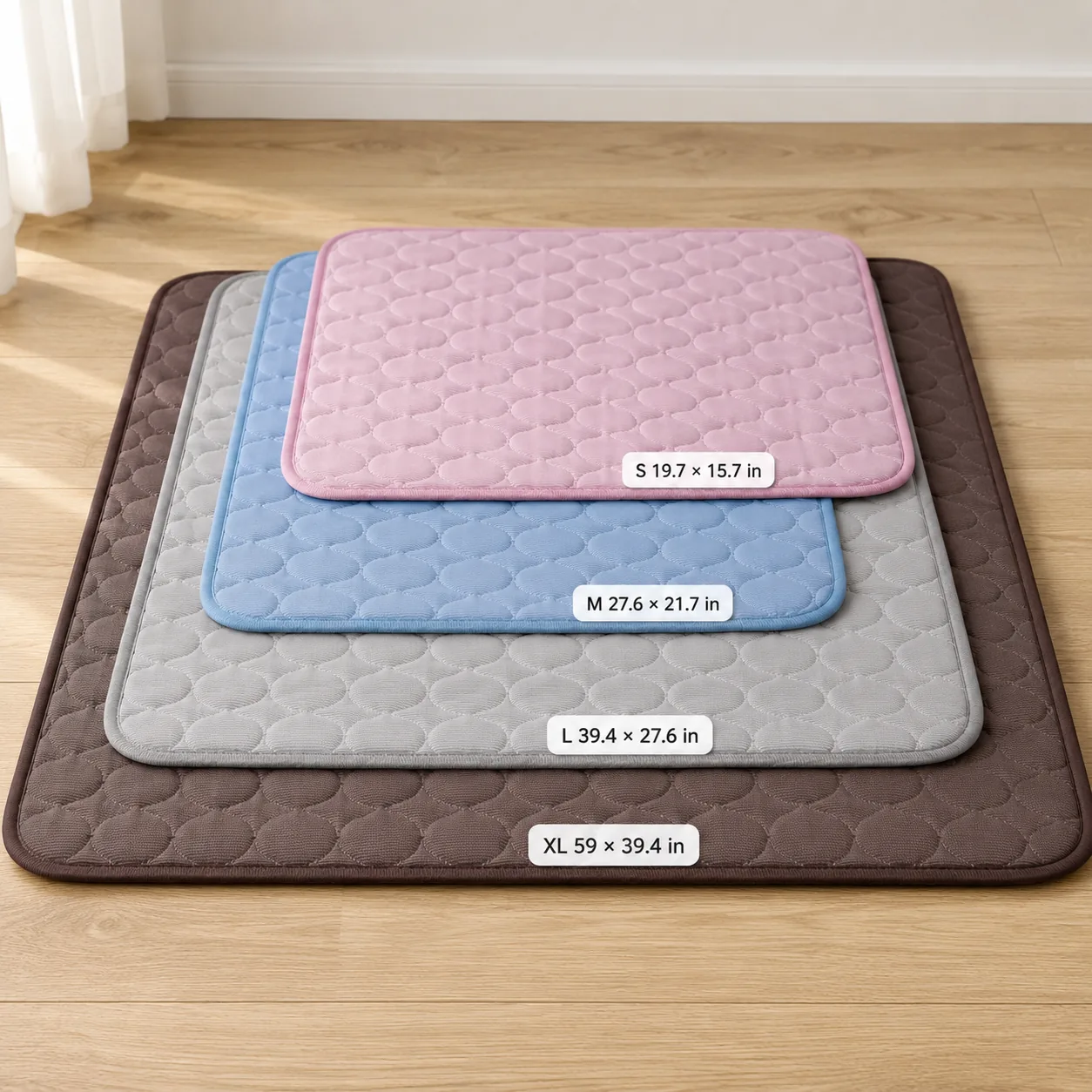 The four Frimouf cooling mats stacked in order of size: pink S, blue M, gray L and brown XL